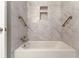 Elegant tub and shower with updated fixtures, marble tile surround, and shelving niche at 2519 Reta St., Conway, SC 29526