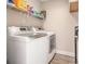 Modern laundry room featuring white washer and dryer, upper cabinets, and shelving at 2521 Wise Rd., Conway, SC 29526