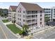 Aerial view of a condo exterior offering balconies overlooking a lush lawn at 2710 South Ocean Blvd. # 208, Myrtle Beach, SC 29577