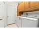 Functional laundry room with upper cabinets and a full-size washer and dryer set at 2995 Woodberry Ct., Little River, SC 29566