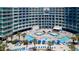 Aerial view of a luxurious beachfront resort with a large outdoor pool and plenty of lounge chairs at 304 North Ocean Blvd. # 506, North Myrtle Beach, SC 29582