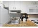 This kitchen features white cabinets, granite countertops, and stainless steel sink at 304 North Ocean Blvd. # 506, North Myrtle Beach, SC 29582