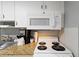Kitchen offers white cabinets, microwave, and glass-top stove at 304 North Ocean Blvd. # 506, North Myrtle Beach, SC 29582