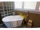 Well-lit bathroom featuring a soaking tub with glass block shower and a woven accent wall at 329 Kauffman St., Georgetown, SC 29440
