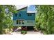 Two-story blue home featuring a unique design with wooden supports and lush green landscaping at 329 Kaufman St., Georgetown, SC 29440