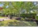 Landscaped backyard featuring a brick patio with an outdoor kitchen and mature trees at 4 Stillwater Ct., Murrells Inlet, SC 29576