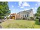 Landscaped backyard featuring a patio with a pergola, yellow seating, and a barbecue grill at 4 Stillwater Ct., Murrells Inlet, SC 29576