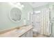 A well-lit bathroom showcasing a round mirror, white vanity, and a bathtub with shower at 4 Stillwater Ct., Murrells Inlet, SC 29576