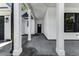 Inviting covered porch with white pillars, modern lighting, and a view of the front door at 4120 Whatuthink Rd., Myrtle Beach, SC 29588