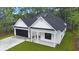 Beautiful modern home with manicured lawn, white siding, and black accents on a sunny day at 4120 Whatuthink Rd., Myrtle Beach, SC 29588