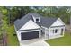 Lovely home with a dark garage door, white siding, and black roof nestled in a wooded setting at 4120 Whatuthink Rd., Myrtle Beach, SC 29588