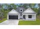 Charming home featuring white siding, a black garage door, and a cozy covered front porch at 4120 Whatuthink Rd., Myrtle Beach, SC 29588