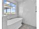 Bright bathroom with a white soaking tub, marble wall tile, and views of the community at 437 Saint Julian Ln., Myrtle Beach, SC 29579