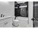 A modern bathroom features a shower and tub combo with black tile and a white vanity at 437 Saint Julian Ln., Myrtle Beach, SC 29579