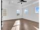A bright bedroom featuring hardwood flooring, a ceiling fan, and many windows at 437 Saint Julian Ln., Myrtle Beach, SC 29579