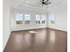 Spacious main bedroom with a tray ceiling, ceiling fan, wood floors, and three large windows offering plenty of light at 437 Saint Julian Ln., Myrtle Beach, SC 29579