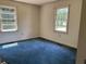 Bright bedroom with dual windows allowing natural light and blue carpeted flooring at 444 Davis Rd., Hemingway, SC 29554