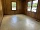 A simple empty room features wood paneling and two large windows for natural light at 444 Davis Rd., Hemingway, SC 29554