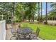Outdoor seating on a patio with lush landscaping and mature trees creates a peaceful backyard oasis at 4803 Bucks Bluff Dr., North Myrtle Beach, SC 29582