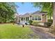 Exterior view of home featuring mature trees, green grass, and a patio with seating at 4803 Bucks Bluff Dr., North Myrtle Beach, SC 29582