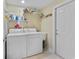 Functional laundry room features a utility sink, washer, dryer, storage shelves, and tile flooring at 4803 Bucks Bluff Dr., North Myrtle Beach, SC 29582