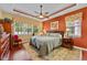 Comfortable main bedroom with tray ceilings, hardwood floors, a ceiling fan, and large windows at 4803 Bucks Bluff Dr., North Myrtle Beach, SC 29582