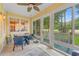 Bright sunroom with large windows, a ceiling fan, and a dining table with blue chairs at 4803 Bucks Bluff Dr., North Myrtle Beach, SC 29582