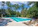 Spacious swimming pool featuring multiple lounge chairs, surrounded by lush trees at 4803 Bucks Bluff Dr., North Myrtle Beach, SC 29582