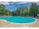 Large swimming pool surrounded by lounge chairs and lush greenery, perfect for relaxation and recreation at 4803 Bucks Bluff Dr., North Myrtle Beach, SC 29582