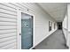 Hallway view of unit entrance with a storm door and light-colored vinyl siding at 4811 Innisbrook Ct. # 306, Myrtle Beach, SC 29579