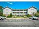 Exterior shot of a three-story condo building with white balconies and well-maintained landscaping at 4811 Innisbrook Ct. # 306, Myrtle Beach, SC 29579