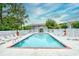 Community pool surrounded by lounge chairs and a white picket fence, with trees at 4811 Innisbrook Ct. # 306, Myrtle Beach, SC 29579