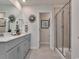A bathroom featuring a double vanity with gray cabinetry, white countertops, and a glass-enclosed shower at 4861 Hopespring St., Myrtle Beach, SC 29579