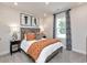 Cozy bedroom featuring a bed with an orange quilt, stylish curtains, and decorative artwork at 4861 Hopespring St., Myrtle Beach, SC 29579