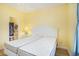Bedroom features twin beds, light wood flooring, yellow walls, and an ensuite bathroom at 488 River Oaks Dr. # 61N, Myrtle Beach, SC 29579