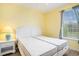 Bedroom features twin beds, light wood flooring, a window with curtains, and yellow walls at 488 River Oaks Dr. # 61N, Myrtle Beach, SC 29579