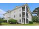 Exterior of a multi-story building with screened-in balconies and well-manicured landscaping at 488 River Oaks Dr. # 61N, Myrtle Beach, SC 29579