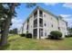 Three-story condo building with screened-in decks, lush greenery, and golf course views at 488 River Oaks Dr. # 61N, Myrtle Beach, SC 29579