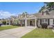 View of multiple townhomes with well-kept lawns, covered carports, and brick details under a blue sky at 511 Colonial Trace Dr. # 7-C, Longs, SC 29568