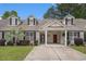 Charming townhome featuring a covered carport, brick accents, manicured lawn, and dormer windows at 511 Colonial Trace Dr. # 7-C, Longs, SC 29568