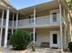 Charming condo exterior showcasing private balconies with white railings and a bench in the courtyard at 5206 Sweetwater Blvd. # 5206, Murrells Inlet, SC 29576