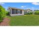 Manicured backyard featuring green grass and a screened-in porch at 535 Wildflower Trail, Myrtle Beach, SC 29579