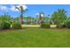 Scenic backyard with well-manicured lawn and view of tall palm trees at 535 Wildflower Trail, Myrtle Beach, SC 29579