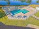 Aerial view showcasing the community pool surrounded by tables, chairs, and a lake backdrop at 535 Wildflower Trail, Myrtle Beach, SC 29579