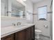 Bathroom featuring white tile, a vanity with a white countertop, a large mirror, and a glass-door shower at 6001-1454 S Kings Hwy., Myrtle Beach, SC 29575