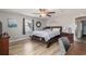 Bright main bedroom boasts a ceiling fan, wood floors, and a comfortable bed with stylish furniture at 6001-1454 S Kings Hwy., Myrtle Beach, SC 29575