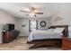 Bright main bedroom boasts a ceiling fan, wood floors, and a comfortable bed with stylish furniture at 6001-1454 S Kings Hwy., Myrtle Beach, SC 29575