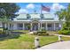 Community clubhouse featuring a lawn, garden beds, covered front porch and American flag at 603 Sea Island Way, North Myrtle Beach, SC 29582