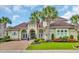 Stunning home with a well-manicured lawn, lush flowerbeds, brick driveway, and beautiful palm trees at 603 Sea Island Way, North Myrtle Beach, SC 29582