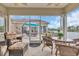 Screened-in porch with wicker furniture overlooking a serene lake and manicured backyard at 603 Sea Island Way, North Myrtle Beach, SC 29582